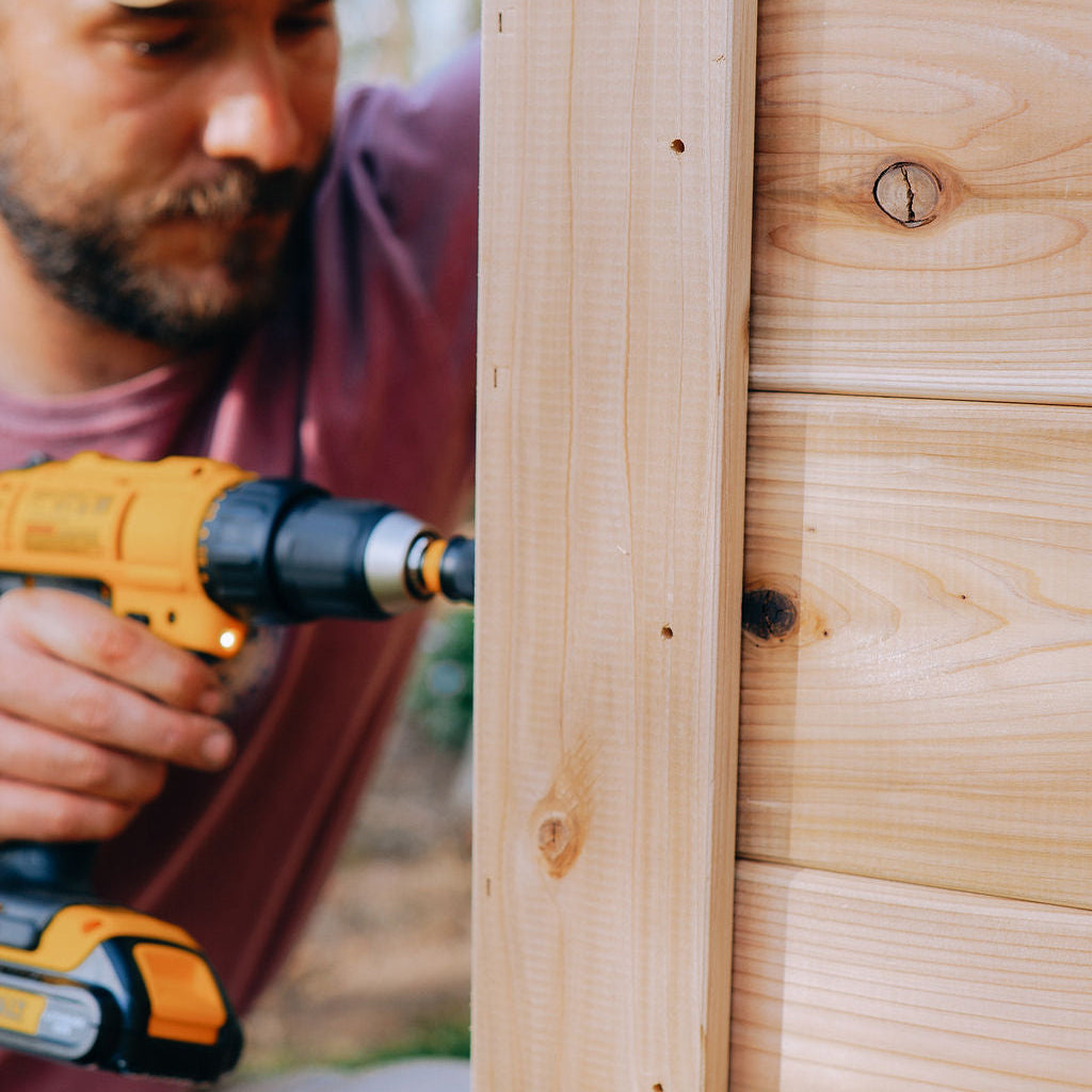 Person installing trim on raised garden beds